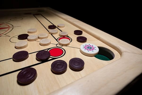 Carrom board with striker and coins